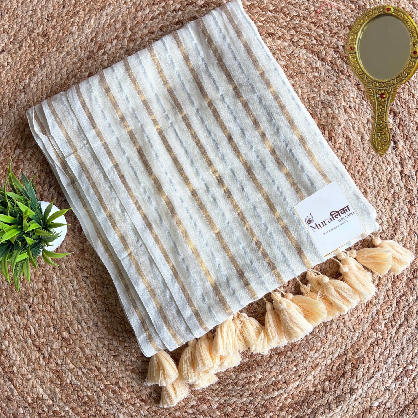 Detail of alternating gold and silver zari stripes on the ivory mulmul saree