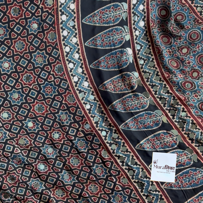 Chandani Ajrakh saree draped, showing the black-ground star lattice block print